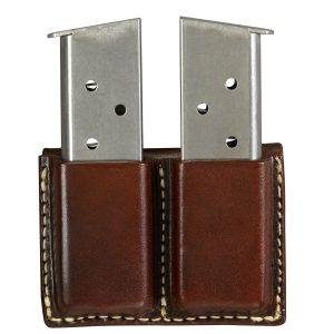 A Cowboy Dual Open Top Magazine Carrier is a leather pouch designed to hold two silver metal firearm magazines.
